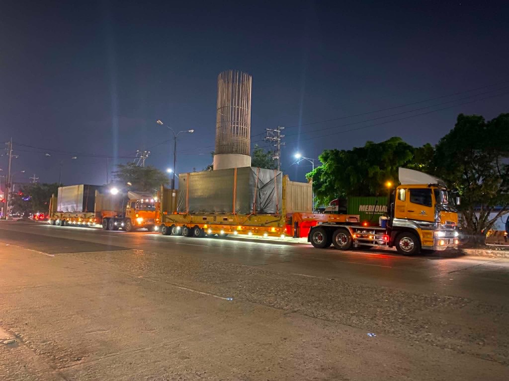 Yellow heavy-haul trucks transporting oversized cargo at night