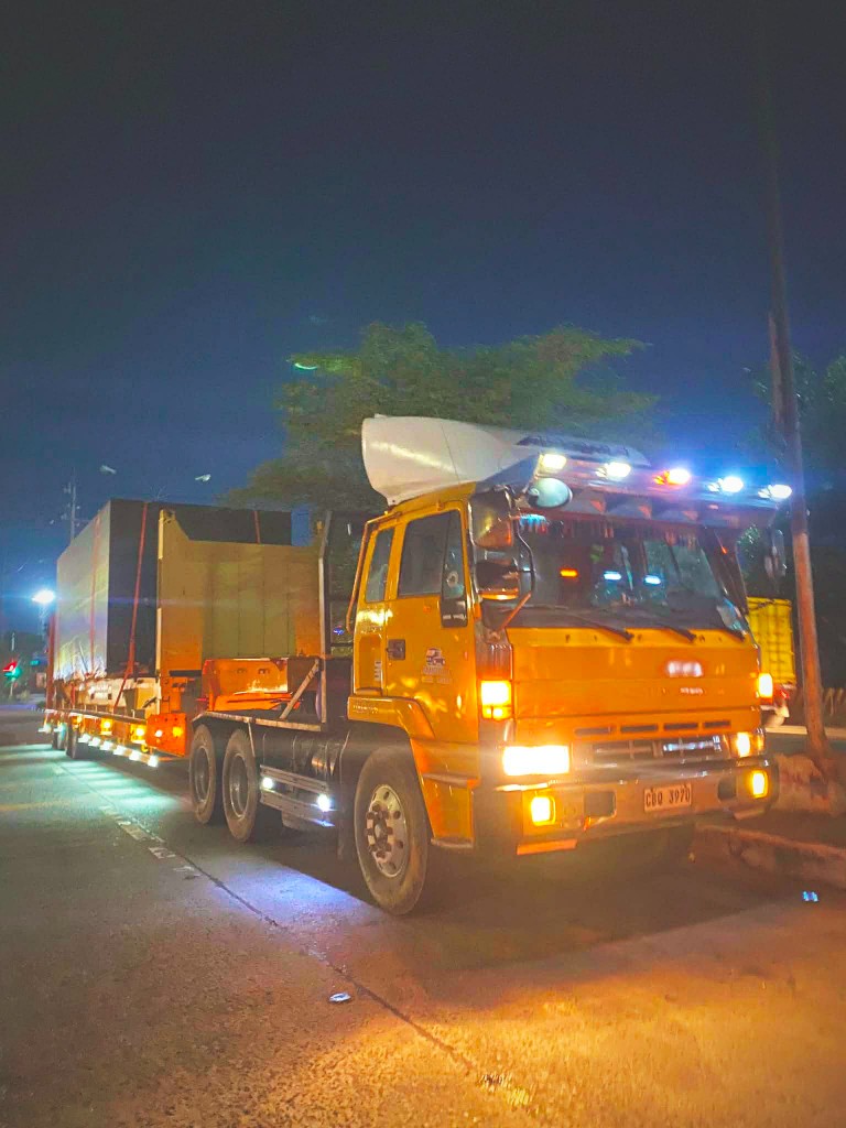 Yellow heavy-haul truck carrying oversized cargo at night